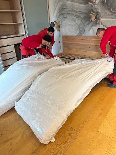 Team verpackt Matratze sorgfältig